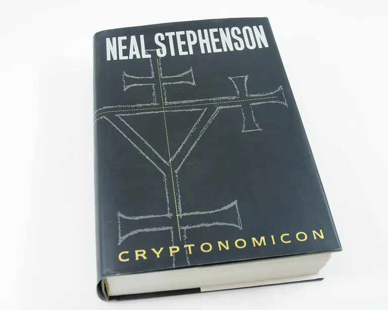 My hardback copy of Neal Stephenson Cryptonomicon, black jacket with chalk-drawn runes
