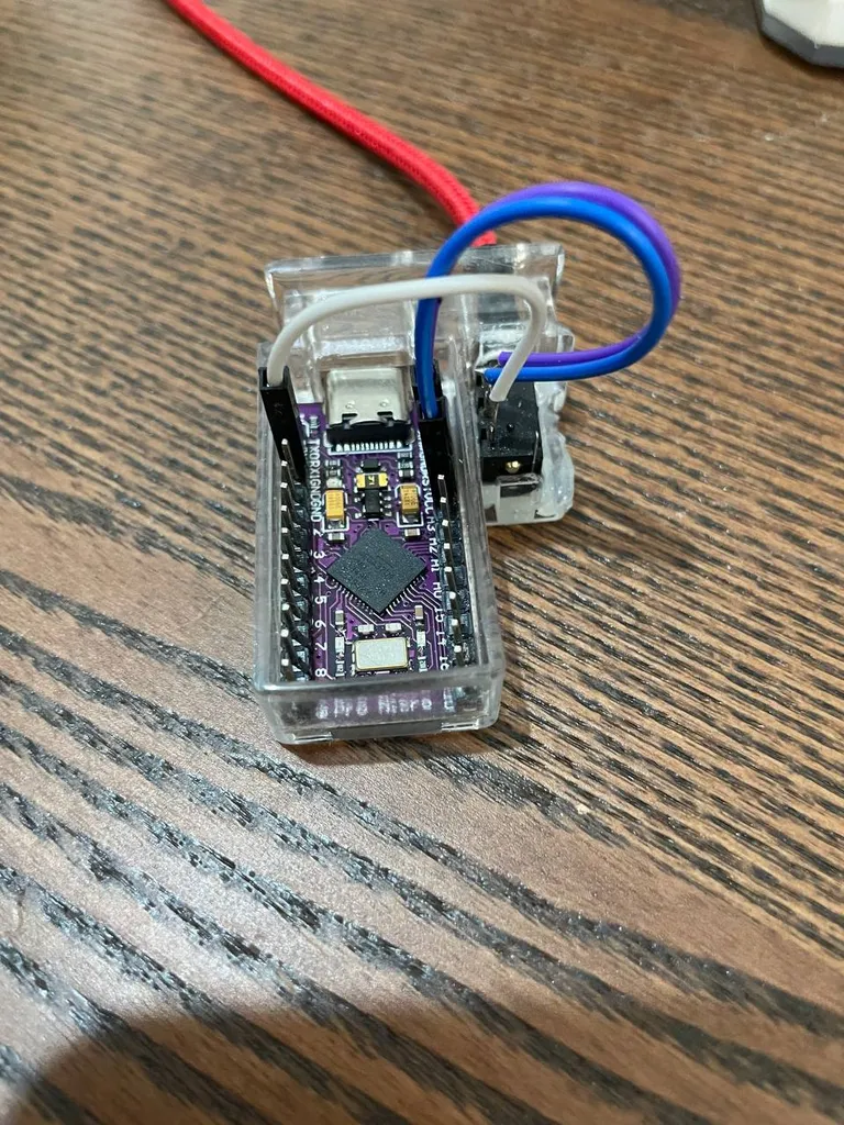 The purple Tenstar Robot Pro Micro clone in its clear resin holder, next to the TRRS jack