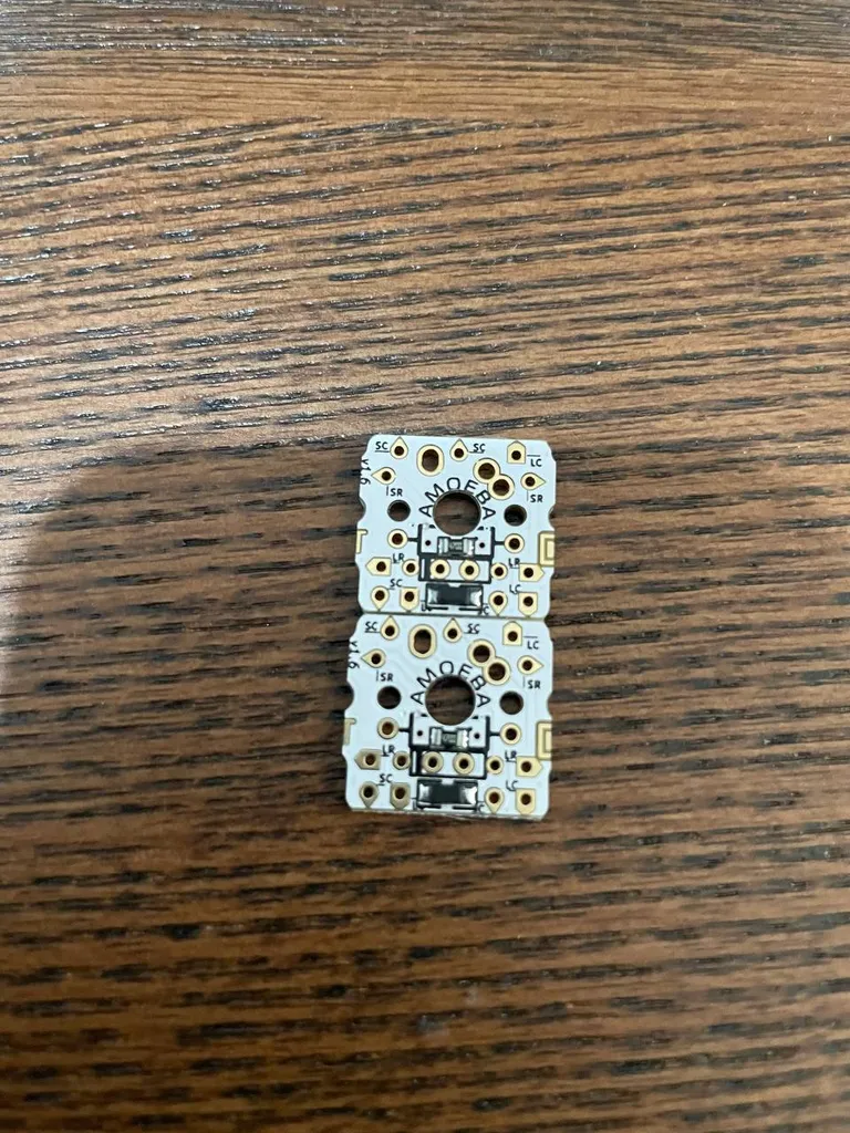 Two Amoeba PCBs showing the side flaps I had to grind off to make them fit