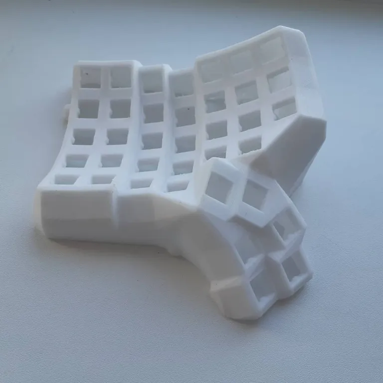 The first Dactyl Manuform half printed in white PETG, key wells still rough from the supports