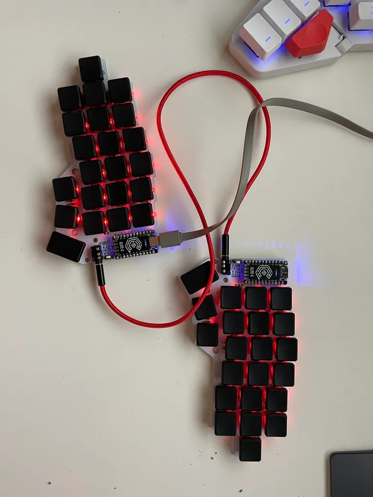 The finished split with black low-profile caps, red RGB underglow and a red braided TRRS cable